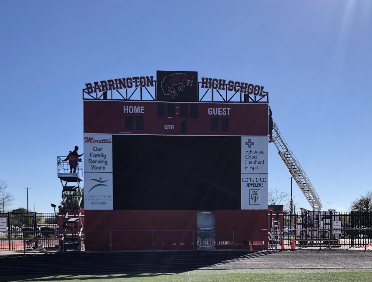 Workers make adjustments to the new scoreboard. Some student athletes were very happy about the upgrade because the old scoreboard had some technical issues. “I think that the changes to the stadium are really cool,” said junior AJ Salam. “Every year I’ve been playing football the scoreboard has worked half of the time, so it was a good idea building a new one.” Photo by Camille Wodarz.