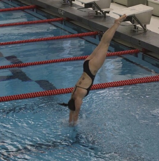 Anna Mae King dives into the water at one of the dual meets this high school swim and dive season. At these dual meets, King was able to measure her progress. “You have to not be afraid to smack and some things hurt obviously but you just have to do it anyway.” she said.