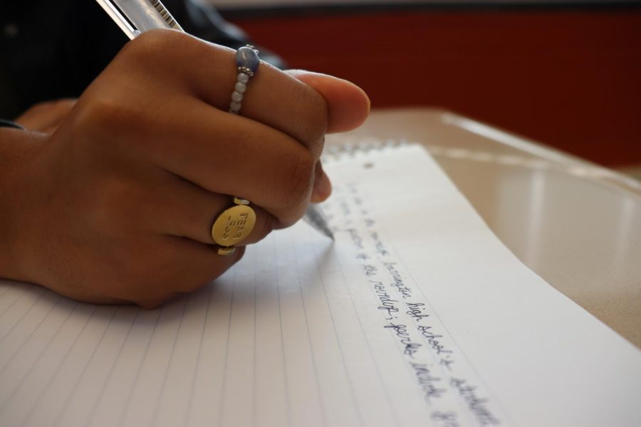 Student writing in cursive. Photo by Sarah Quig, 23.