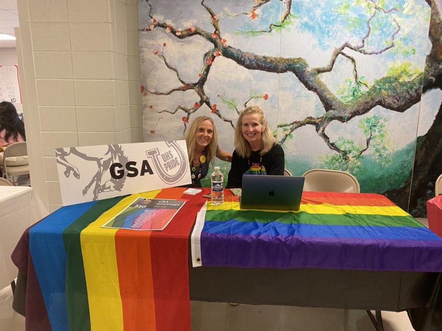 Staff members Amy Winkelman and Janet Anderson sit at the GSA club booth.