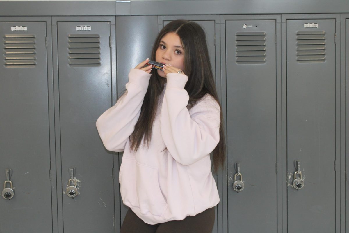 Freshman Maya Ismail plays the harmonica, a hobby she recently found she enjoys. Photo illustration by Brenna Chomicz, '29.